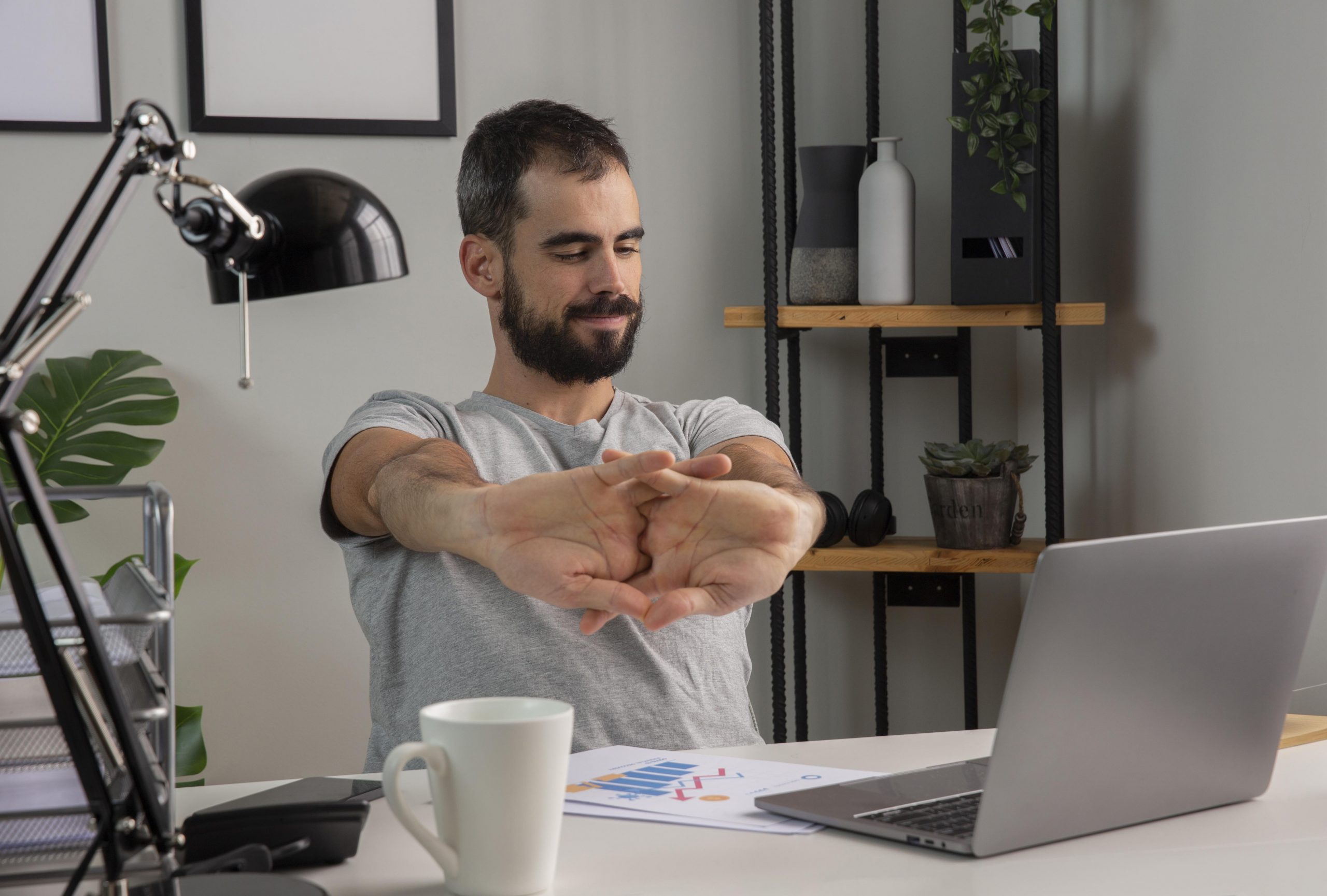man-stretching-his-arms-while-working-from-home