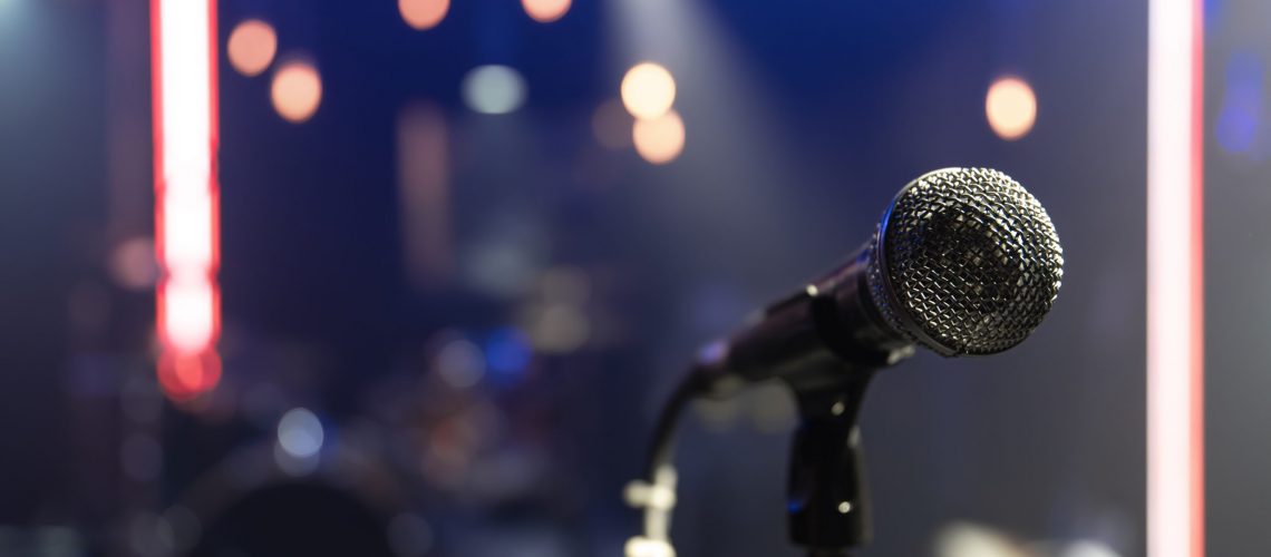 Close up of a microphone on a concert stage with beautiful lighting.